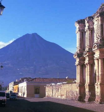 VISTA DESDE UNA CALLE DE ANTIGUA GUATEMALA DONDE SE APRECIA EL VOLCAN DE AGUA Y PARTE DE LA FACHADA DE USA IGLESIA QUE SE LLAMA DEL CARMEN