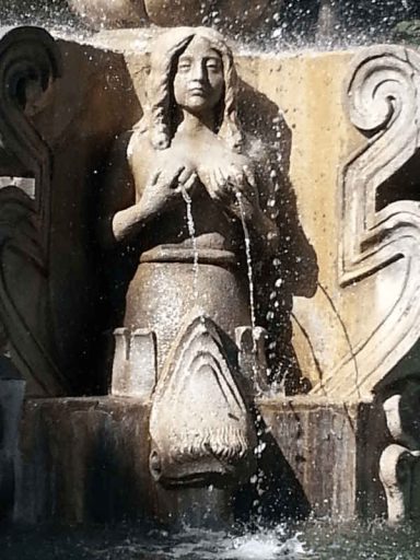 escultura tamaño real de sirena decorando la fuente del parque central de antigua guatemala
